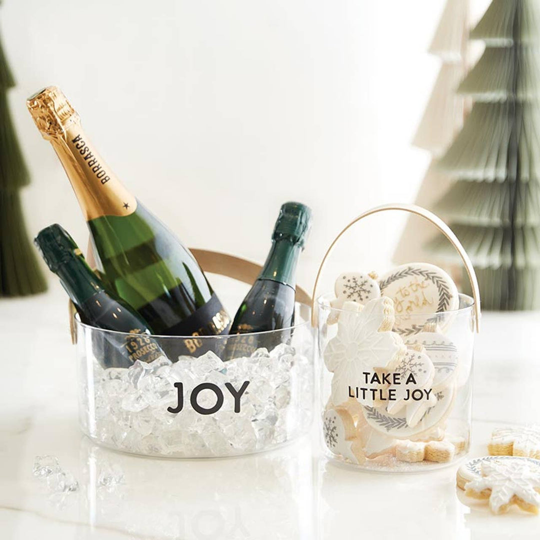 Bottles of champagne in an acrylic bucket labeled &