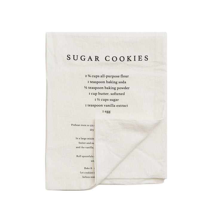 Folded kitchen towel with sugar cookies recipe printed on it against a white background