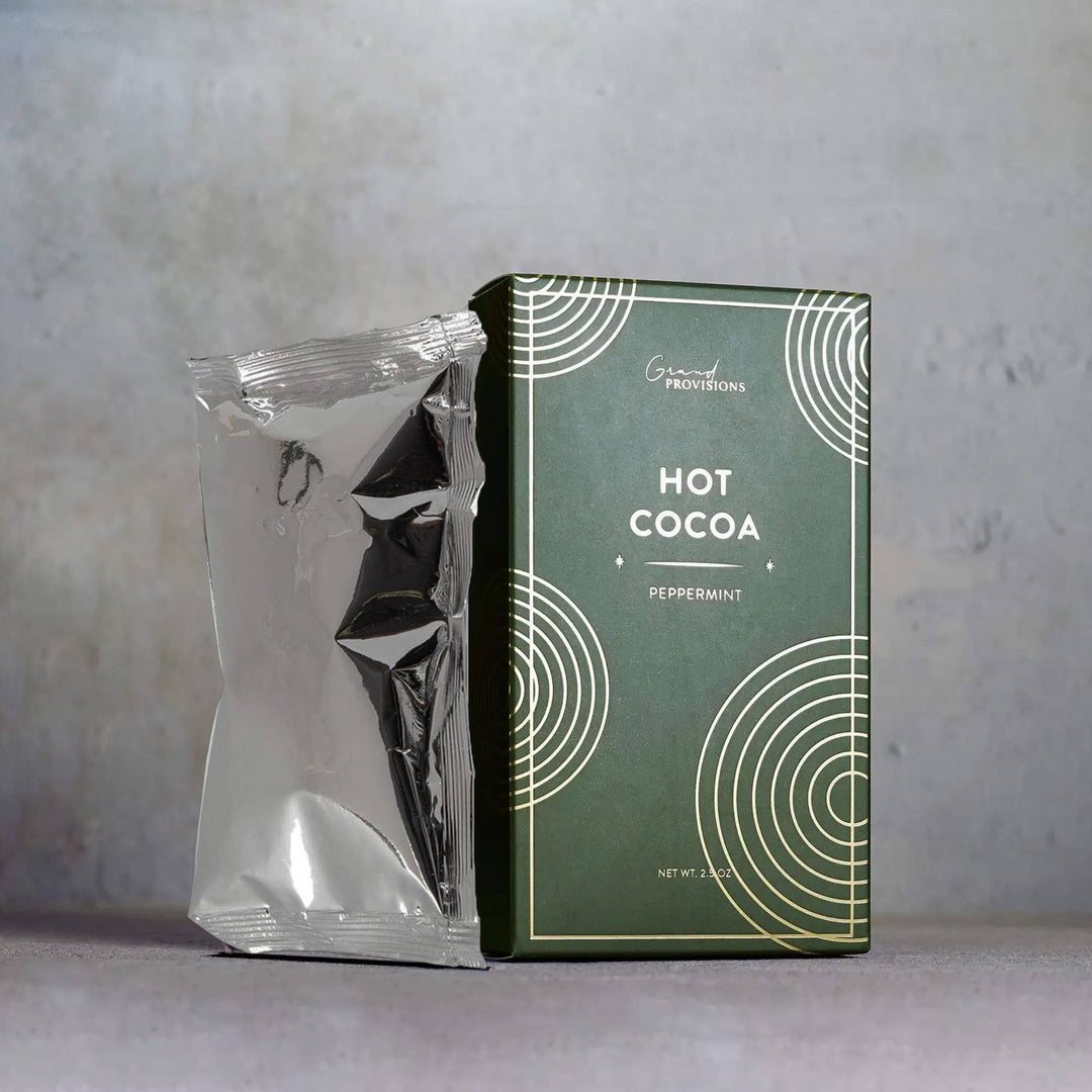 Green box of hot cocoa with a peppermint flavor on a gray background.