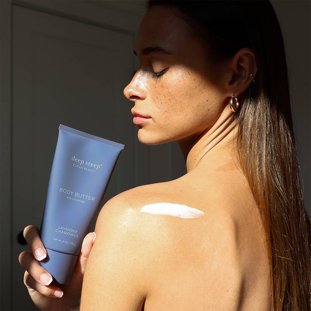 Woman applying body butter to her shoulder with a &