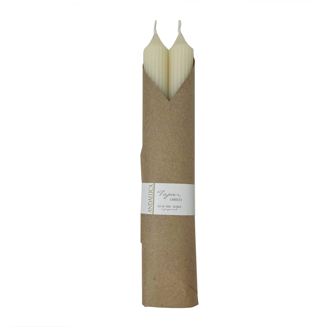 A pair of unscented ivory ridged taper candles, wrapped in paper packaging with a label.