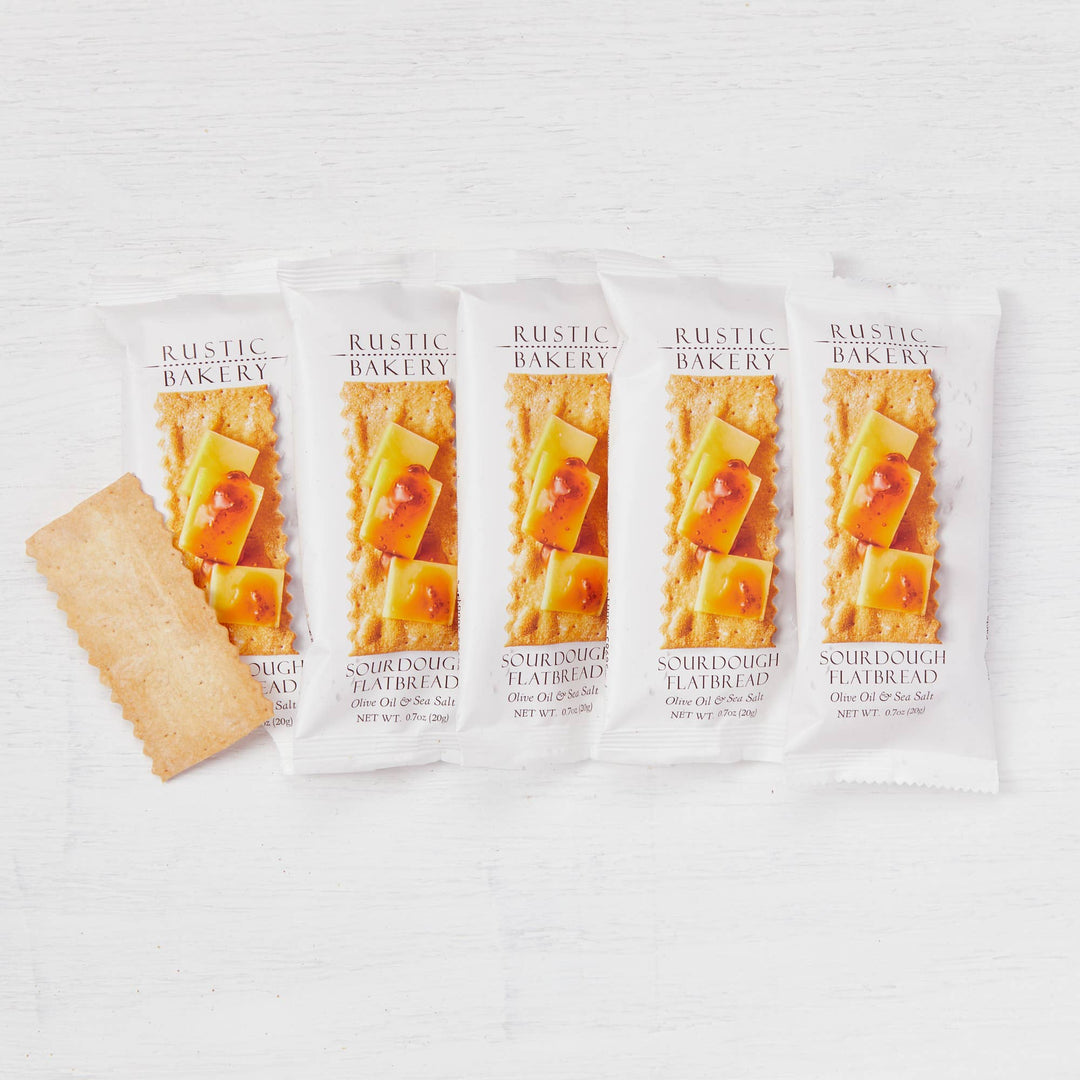 Five packages of Rustic Bakery sourdough flatbread on a white background