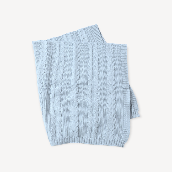Light blue knitted baby blanket on a white background