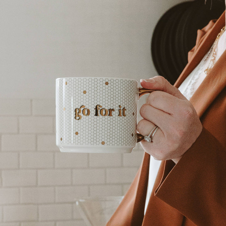 Person holding a mug with &