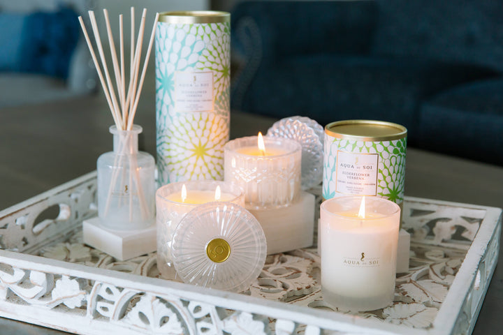 Aqua de Sol candles and diffusers sitting on coffee table tray. 