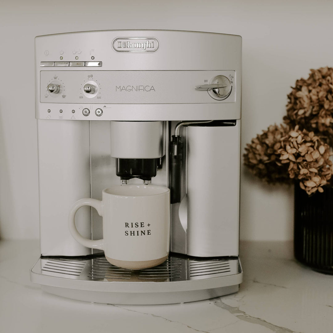 White coffee machine with a mug on a countertop.