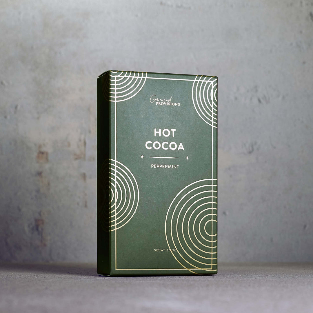 Green packaging of hot cocoa with peppermint flavor on a gray background