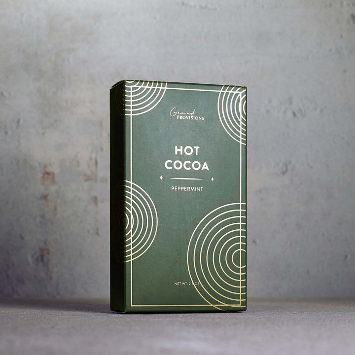Green packaging of hot cocoa with peppermint flavor on a gray background