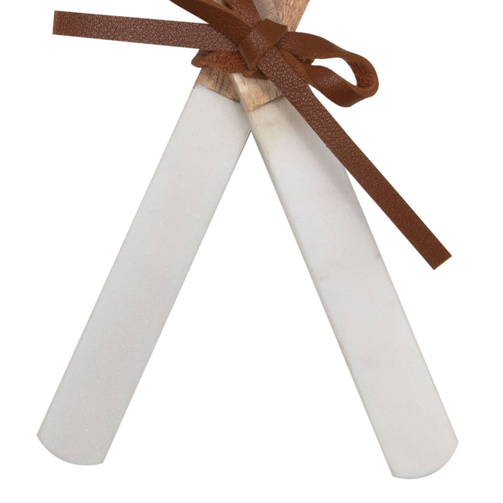 Two marble and wood spoons tied with a brown ribbon on a white background